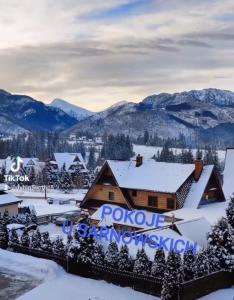 a resort in the snow with mountains in the background at Pokoje u Sarnowskich in Kościelisko