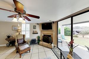 a living room with a ceiling fan and a fireplace at Mainsail IV in Destin