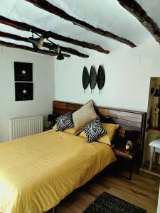 a bedroom with a bed with yellow sheets and pillows at Casa Blanca in Castell de Castells