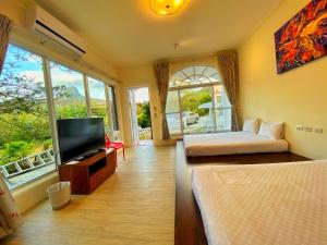 a room with two beds and a television in a room at 獨棟山水心旅棧 in Kenting