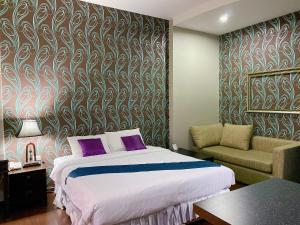Si Maha Phot的住宿－The Desiign Hotel - SHA，一间卧室配有一张床、一张沙发和一把椅子