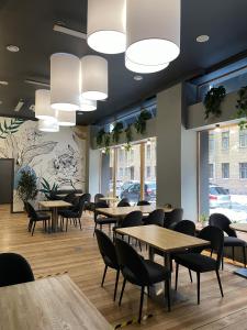 a dining room with tables and chairs and windows at Peterville in Saint Petersburg