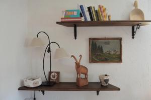 a shelf with a lamp and a picture on a wall at La Maison De José in Aosta