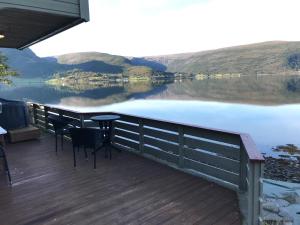 una terraza con mesa y sillas con vistas al lago en Seaside 3-bedroom House en Svelgen