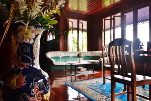 a living room with a vase with flowers in it at Suandarbporn Resort Mae Sot in Mae Sot