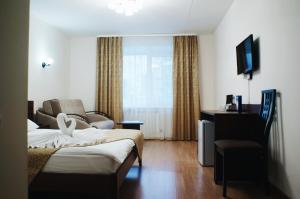 ヤロスラヴリにあるKosmos Hotelのベッドとリビングルームが備わるホテルルームです。