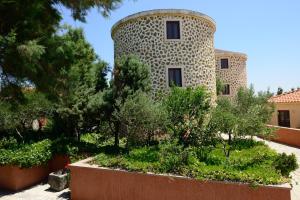 ein Gebäude mit einem Turm mit Bäumen und Sträuchern in der Unterkunft Varos Village Boutique Hotel in Város