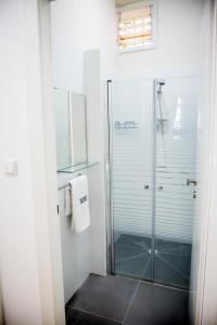 a bathroom with a shower and a glass shower stall at Hostel BU93 in Tel Aviv