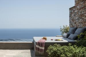 a bed sitting on a patio next to the water at Verina Astra in Artemonas