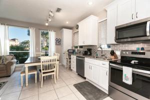 a kitchen with white cabinets and a table and chairs at Destiny Beach Villa 11B in Destin