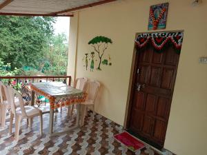 a dining room with a table and chairs and a door at Gharat Cottage in Alibaug