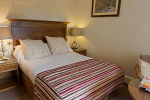 a bedroom with a bed and two lamps and a table at Grinkle Park Hotel in Loftus +57 photos