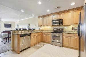 a kitchen with wooden cabinets and stainless steel appliances at Mariners Watch 205 in Ocean City