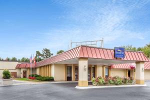 a front view of a hotel with a gas station at Baymont by Wyndham Queensbury/Lake George in Queensbury