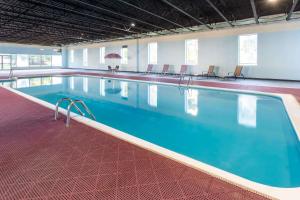 a large swimming pool with blue water in a building at Baymont by Wyndham Queensbury/Lake George in Queensbury