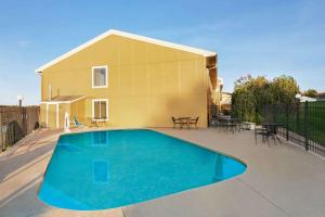 a house with a swimming pool on a patio at Super 8 by Wyndham Hannibal in Hannibal