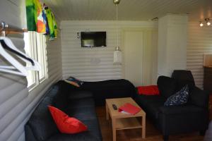 una sala de estar con 2 sofás negros y una mesa. en Svinö Seaside Villa, en Lumparland