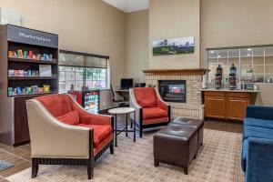 - une salle d'attente avec des chaises et une cheminée dans l'établissement Comfort Suites Fort Collins Near University, à Fort Collins