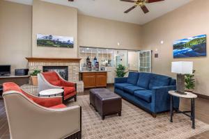 sala de estar con sofá azul y sillas en Comfort Suites Fort Collins Near University, en Fort Collins