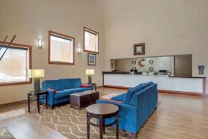una sala de estar con 2 sofás azules y una mesa. en Comfort Inn University Area, en Baton Rouge