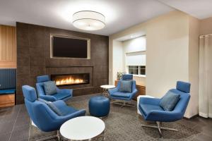 - un hall avec des chaises bleues et une cheminée dans l'établissement Microtel Inn & Suites by Wyndham Warsaw, à Warsaw