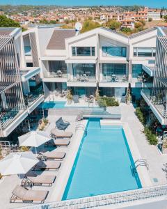 una vista aérea de una piscina del hotel con sillas y sombrillas en Serenity Suites, en Nikiti
