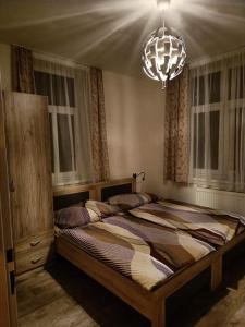 1 dormitorio con 2 camas y lámpara de araña en U pošty, en Albrechtice v Jizerských horách