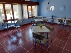 a restaurant with tables and chairs in a room at Hotel Azul Marino in Santa Teresita