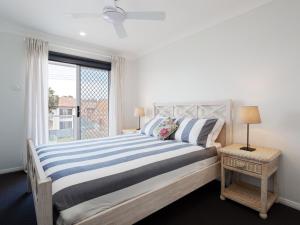 a bedroom with a large bed with a window at Birubi Breezes 2 Large Duplex with Air Conditioning WI FI and only 5 minute walk to the beach in Anna Bay