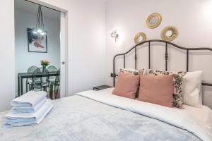 een slaapkamer met een groot bed met roze kussens bij Apartament Królowa Luiza in Zabrze