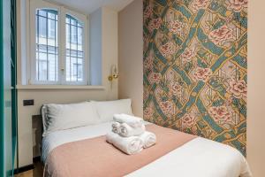 1 dormitorio con 1 cama con pared de flores en Stylish and fancy flat close to Montenapoleone Brera by Easylife, en Milán