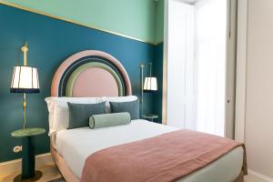 um quarto com uma cama e uma parede azul em The Lift Apartments by RIDAN Hotels em Lisboa
