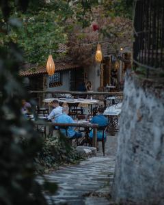 eine Gruppe von Menschen, die an Tischen vor einem Restaurant sitzen in der Unterkunft Serenity Suites in Nikiti