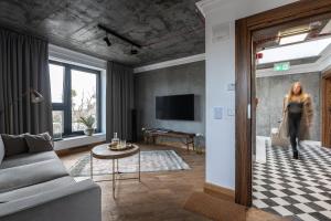 a woman is walking through a living room at Apartamenty Przystanek Przy Klifie in Gdynia