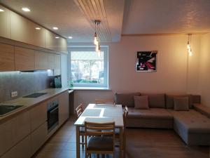 a kitchen and living room with a couch and a table at Poilsis Jums in Nida