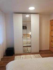 a bedroom with a sliding door with a mirror at Poilsis Jums in Nida