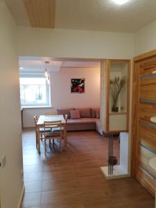 a living room with a table and a couch at Poilsis Jums in Nida +8 photos
