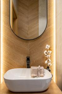 a bathroom with a white sink and a mirror at Modom Holiday Szymony 15 B Aparteo in Zakopane