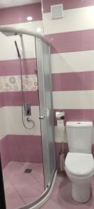 a bathroom with a toilet and a glass shower at Apartament Kostov Sliven in Sliven
