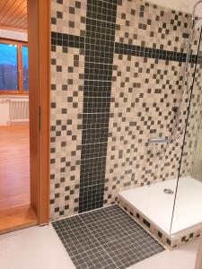 bagno con doccia e piastrelle bianche e nere di Ferienhaus Hämmerle´s a Lustenau