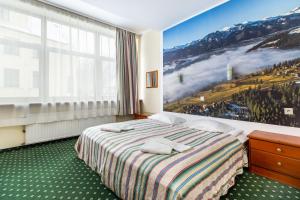 a hotel room with a bed and a large window at Willa Excelsior in Zakopane