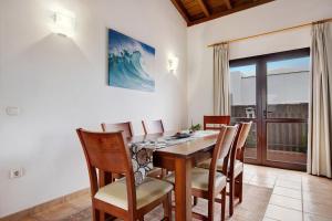 a dining room with a wooden table and chairs at Villa Susana in La Oliva