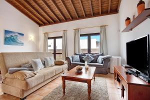 a living room with a couch and a tv at Villa Susana in La Oliva