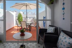 balkon ze stołem, krzesłami i parasolem w obiekcie Casa la Buganvilla-Mojácar Playa w mieście Mojácar