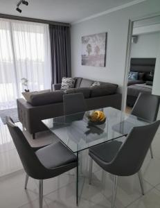 een woonkamer met een glazen tafel en een bank bij Waterfall Luxury Apartment in Midrand