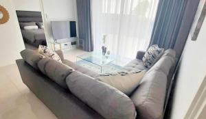 a living room with a couch and a glass table at Stylish Modern 2BR in Waterfall Ellipse - Sleeps 4 - Fast WiFi - Secure Parking in Midrand