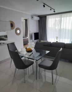 een woonkamer met een glazen tafel en stoelen bij Waterfall Luxury Apartment in Midrand