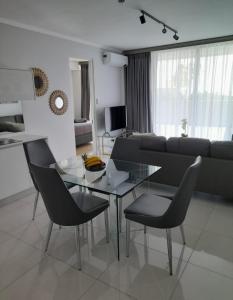 a living room with a glass table and chairs at Waterfall Luxury Apartment in Midrand