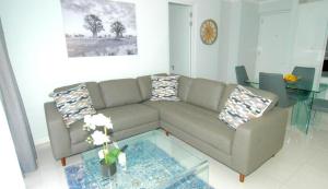 a living room with a couch and a glass table at Stylish Modern 2BR in Waterfall Ellipse - Sleeps 4 - Fast WiFi - Secure Parking in Midrand