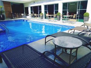 une piscine avec des tables et des chaises dans un hôtel dans l'établissement Hotel Serra de Jundiaí, à Jundiaí